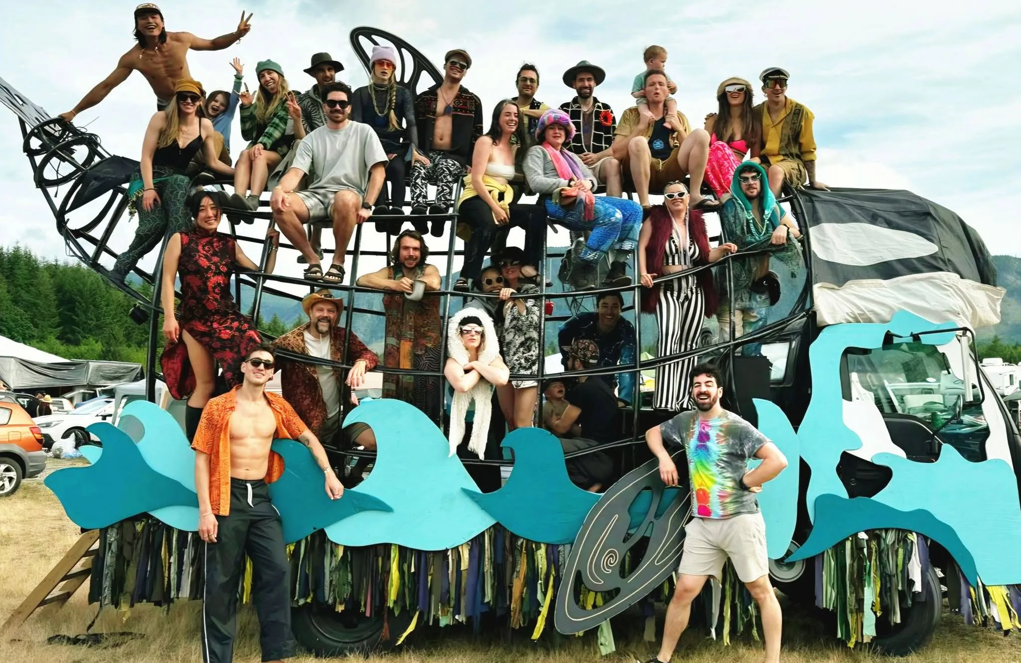 Around twenty people aboard the Orcar in daylight, showing the scale and capacity of the art car