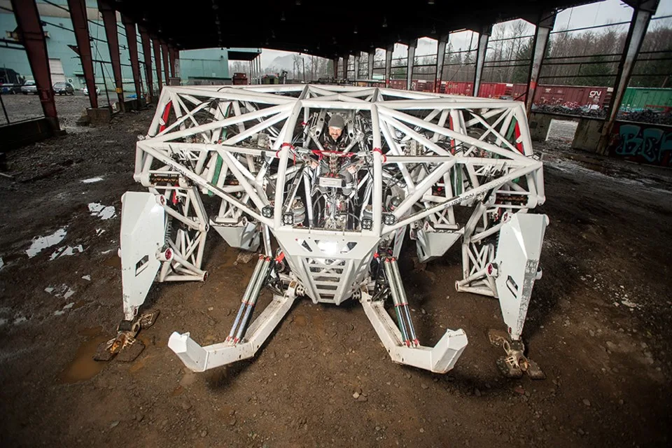 Prosthesis crouched inside a derelict industrial shed