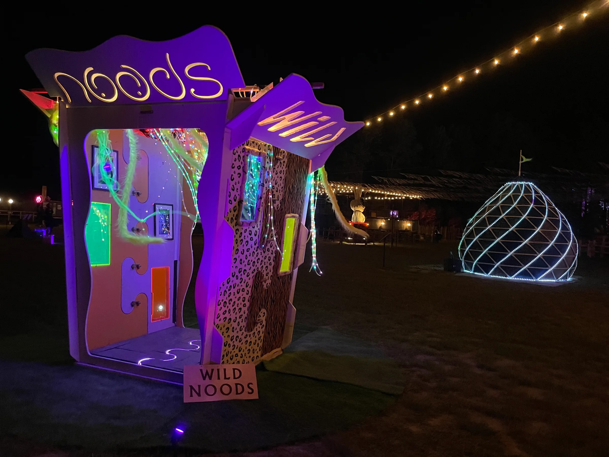 The Noodle Box as Wild Noods: animal-print wrap, laser-cut WILD and NOODS lid panels, and a glowing noodle curtain at night