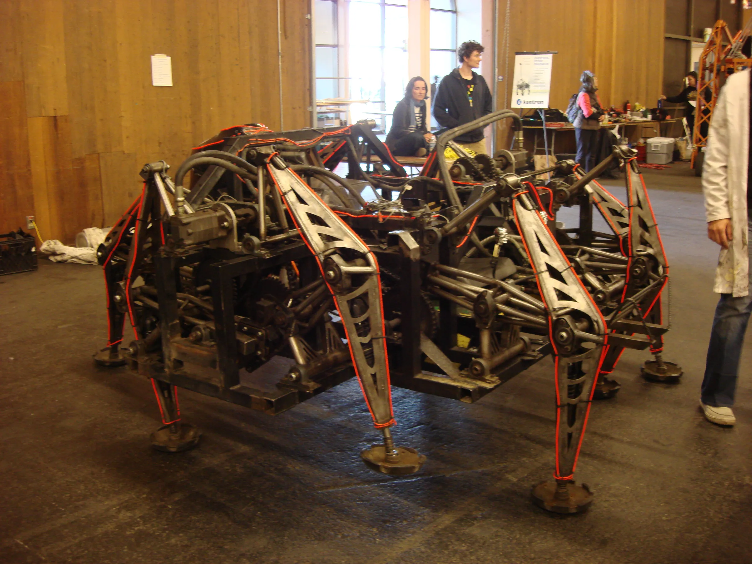 The Mondo Spider indoors, showing its red steel legs and the Klann linkage